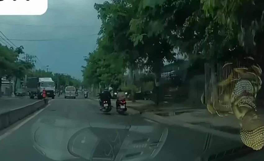 Hai nam thanh niên áp sát cô gái chạy xe để cướp giật điện thoại. Ảnh chụp từ clip Hai nam thanh niên áp sát cô gái chạy xe để cướp giật điện thoại. Ảnh chụp từ clip