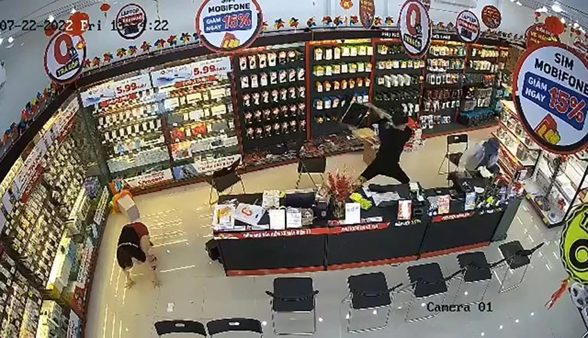 Nam nhân viên dùng ghế chống cự lại người đàn ông cướp tài sản. Ảnh chụp từ clip Nam nhân viên dùng ghế chống cự lại người đàn ông cướp tài sản. Ảnh chụp từ clip
