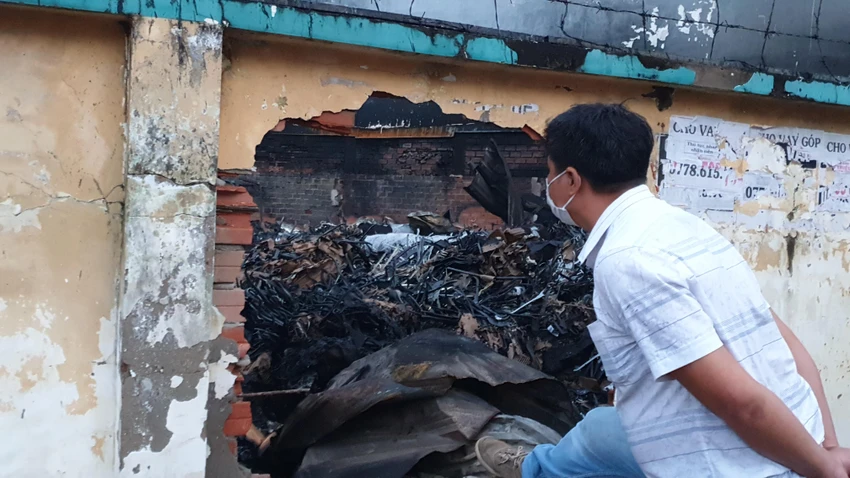 Cảnh sát phá thủng bức tường bên ngoài để xịt nước, dập lửa. Ảnh: NT Cảnh sát phá thủng bức tường bên ngoài để xịt nước, dập lửa. Ảnh: NT