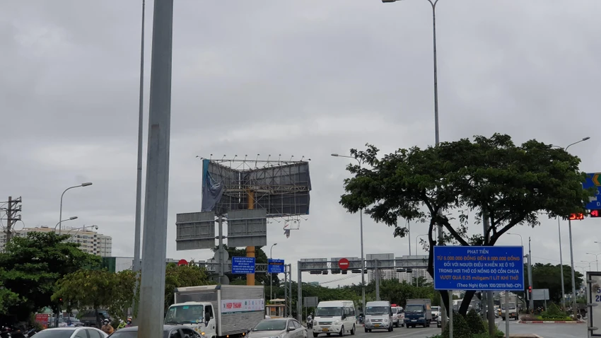 Biển quảng cáo ven đường Võ Văn Kiệt bị gió lốc cuốn bay. Ảnh: NT Biển quảng cáo ven đường Võ Văn Kiệt bị gió lốc cuốn bay. Ảnh: NT