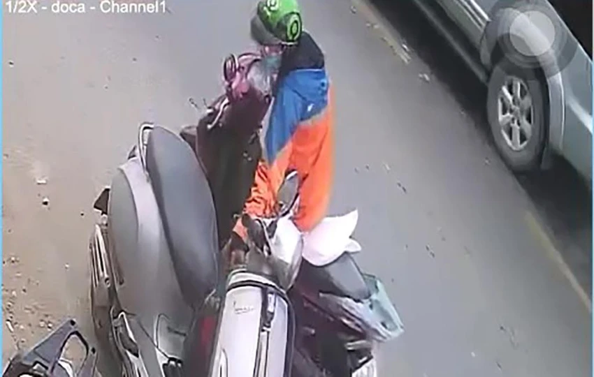 Trước đó, người này đã chạy ngang qua và phát hiện chiếc ba lô treo trên xe máy. Ảnh chụp từ clip Trước đó, người này đã chạy ngang qua và phát hiện chiếc ba lô treo trên xe máy. Ảnh chụp từ clip