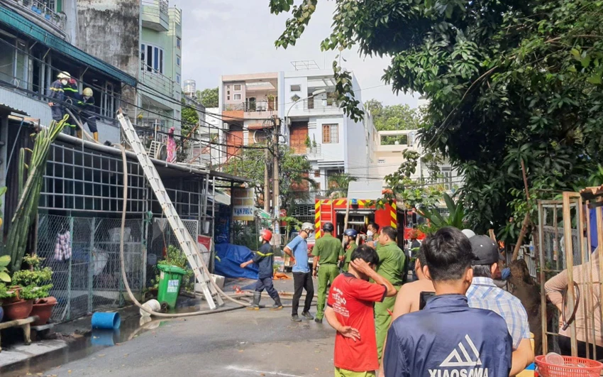 Cảnh sát leo lên mái nhà khống chế đám cháy. Ảnh: HT Cảnh sát leo lên mái nhà khống chế đám cháy. Ảnh: HT