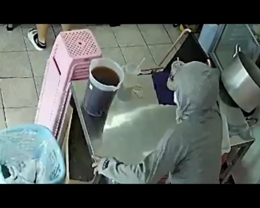 Trước đó, một nam thanh niên vờ vào mua trà sữa nhưng thực ra là dàn cảnh trộm một điện thoại của nhân viên quán. Ảnh chụp từ clip Trước đó, một nam thanh niên vờ vào mua trà sữa nhưng thực ra là dàn cảnh trộm một điện thoại của nhân viên quán. Ảnh chụp từ clip