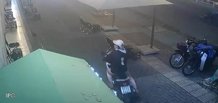 Sau khi lấy chiếc điện thoại, người này nhanh chóng rời đi. Ảnh chụp từ clip Sau khi lấy chiếc điện thoại, người này nhanh chóng rời đi. Ảnh chụp từ clip