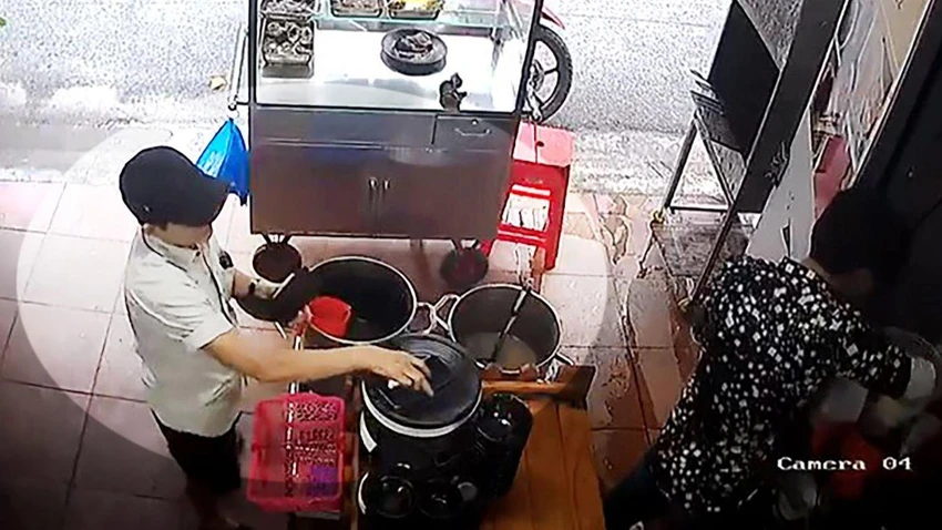 Trước đó, người phụ nữ tới mua cơm rồi lấy chiếc điện thoại khi anh D không chú ý. Ảnh chụp từ clip Trước đó, người phụ nữ tới mua cơm rồi lấy chiếc điện thoại khi anh D không chú ý. Ảnh chụp từ clip