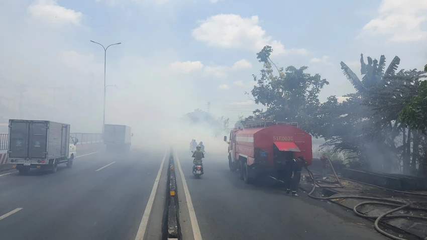 Đám cháy bùng lên từ bãi cỏ rác ven Quốc lộ 1 sau đó lan rộng. Ảnh: HT Đốt rác làm cháy lan uy hiếp hàng chục căn nhà trọ ven Quốc lộ 1