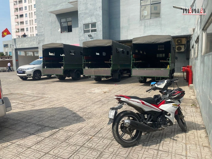 Bên ngoài, nhiều xe tải chuyên dụng đậu dưới sân chung cư. Ảnh: HĐ