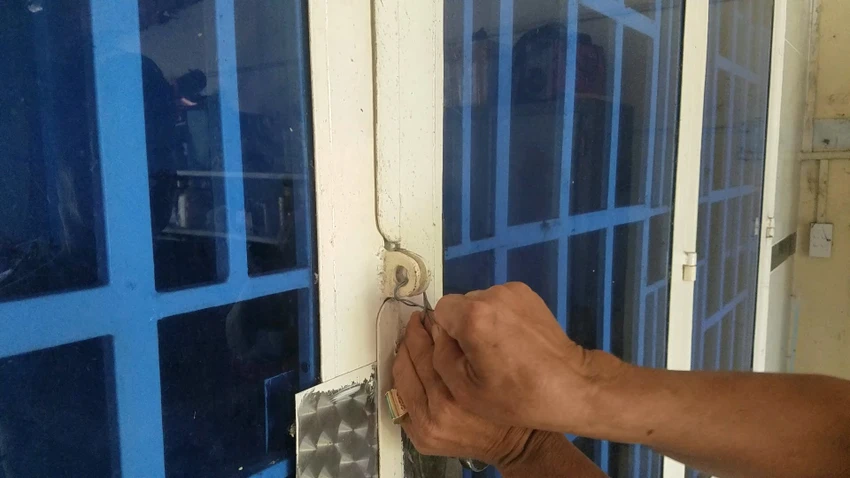 Kẻ gian còn dùng dây kim loại cột khoen cửa trước khi rời đi. Ảnh: HT Kẻ gian còn dùng dây kim loại cột khoen cửa trước khi rời đi