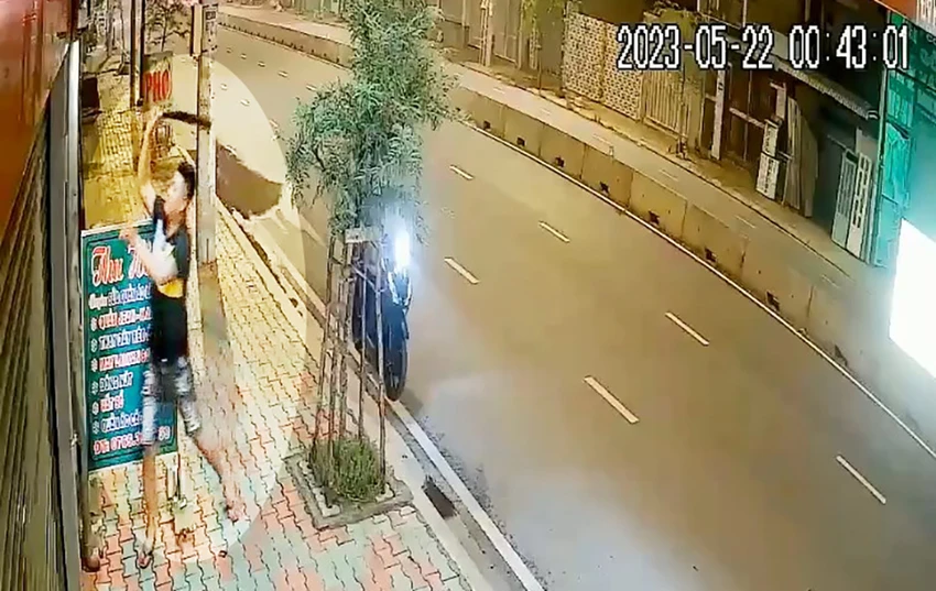 Nam thanh niên cầm theo cây dao dài, chém camera an ninh của cửa hàng kinh doanh trên đường Đặng Thúc Vịnh. Ảnh cắt từ clip Nam thanh niên cầm theo cây dao dài, chém camera an ninh của cửa hàng kinh doanh trên đường Đặng Thúc Vịnh. Ảnh cắt từ clip