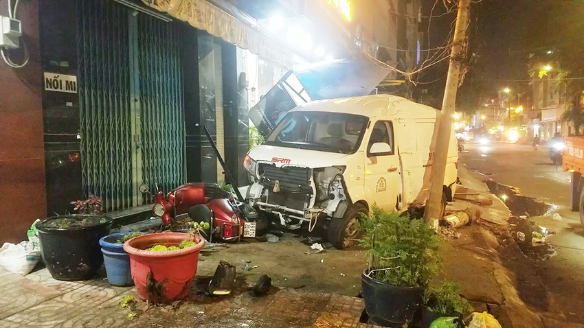 Chiếc xe ô tô tông trúng cột điện và xe máy trên vỉa hè. Ảnh: HT Chiếc xe ô tô tông trúng cột điện và xe máy trên vỉa hè. Ảnh: HT