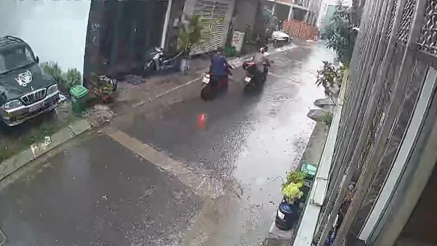 Kẻ gian dùng chân đẩy xe máy rời đi. Ảnh cắt từ clip Kẻ gian dùng chân đẩy xe máy rời đi. Ảnh cắt từ clip