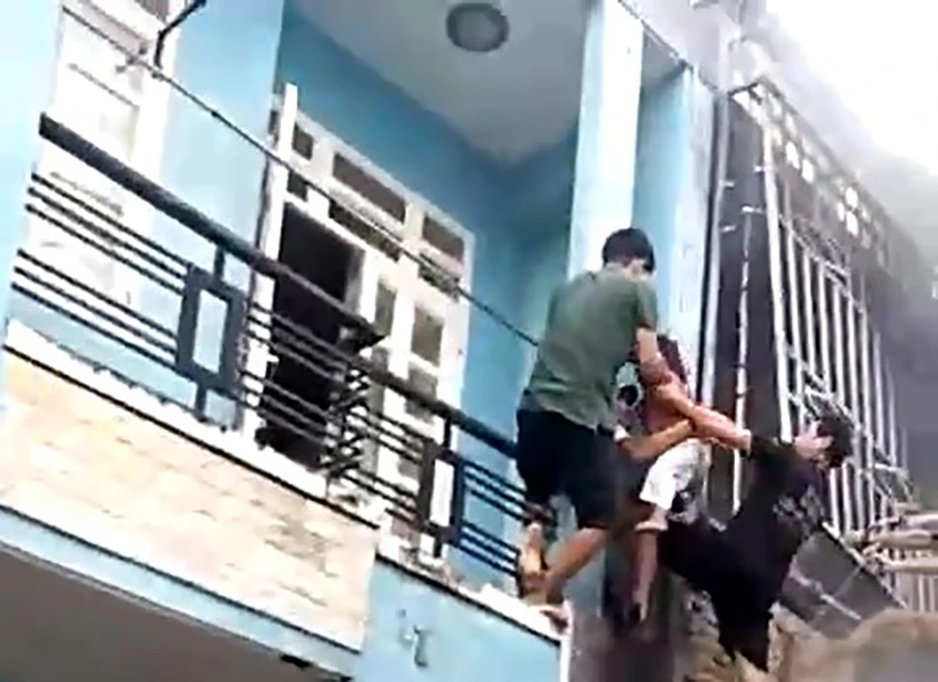 Người dân cùng lực lượng chức năng đã giải cứu ba người, trong đó có một cháu bé trong căn nhà cháy ra ngoài an toàn. Ảnh: HT