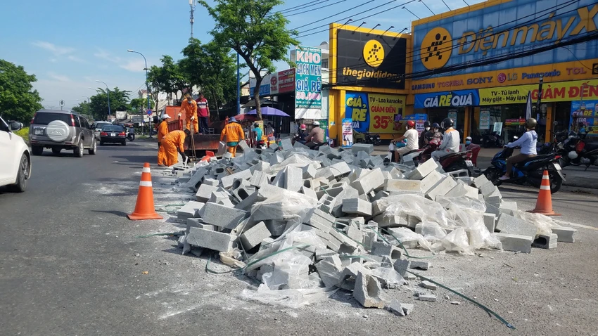 Các công nhân thuộc đơn vị quản lý tuyến đường được huy động để thu dọn đống gạch. Ảnh: HT Các công nhân thuộc đơn vị quản lý tuyến đường được huy động để thu dọn đống gạch. Ảnh: HT