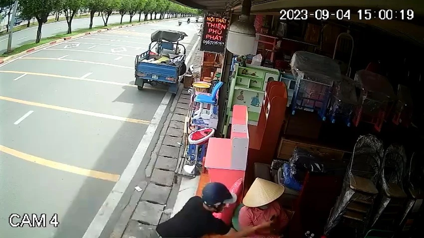 Trước đó, Tuấn dừng xe trước cửa hàng nội thất rồi cướp giật iPhone của người phụ nữ. Ảnh cắt từ clip Trước đó, Tuấn dừng xe trước cửa hàng nội thất rồi cướp giật iPhone của người phụ nữ. Ảnh cắt từ clip