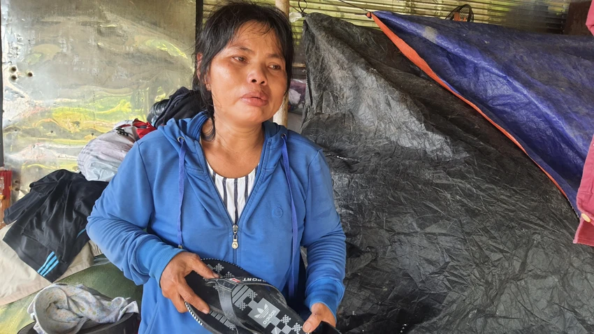 Chị Bọ khóc, ôm đôi dép của con trai lớn trong căn nhà tạm bợ. Ảnh: NT Chị Bọ khóc, ôm đôi dép của con trai lớn trong căn nhà tạm bợ. Ảnh: NT