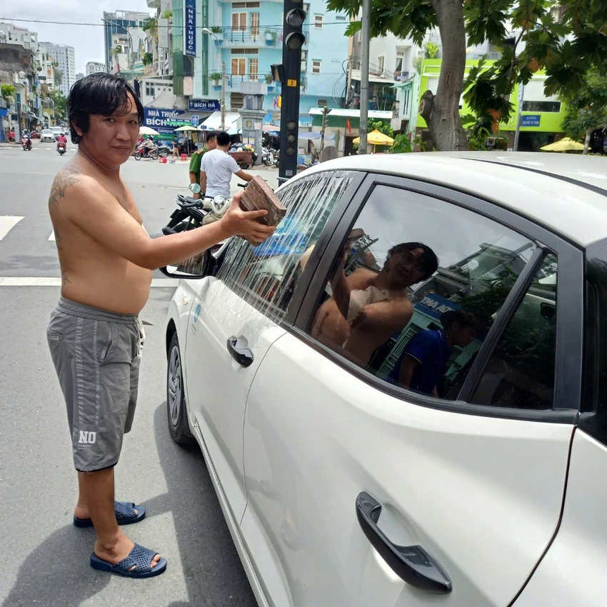 nguoi-dan-ong-o-quan-1-dap-pha-xe-taxi-sau-khi-con-trai-goi-ra-tra-tien-den-bu.jpg
