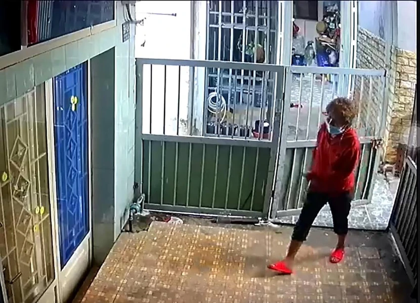 Hình ảnh một phụ nữ mở cửa đi vào nhà bà M. Ảnh: Cắt từ clip Hình ảnh một phụ nữ mở cửa đi vào nhà bà M. Ảnh: Cắt từ clip