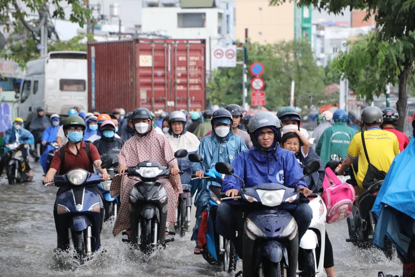 Đến 17 giờ, lượng phương tiện đổ về khu vực tăng cao khiến người đi xe máy càng trở nên chật vật trong dòng nước. Ảnh: ĐC