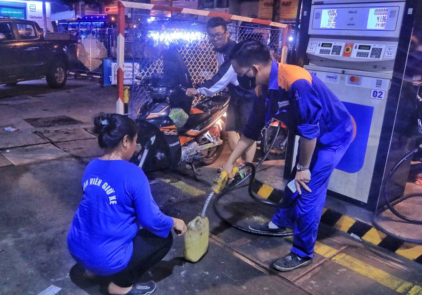 Bà Hồng mang can nhựa đến mua xăng do xe máy ở nhà đã hết xăng.