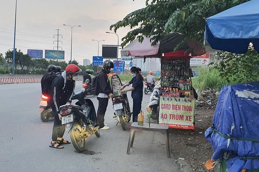 Nhiều người chấp nhận mua xăng giá cao từ các điểm bán xăng lẻ bên đường. Ảnh: NY Nhiều người chấp nhận mua xăng giá cao từ các điểm bán xăng lẻ bên đường. Ảnh: NY
