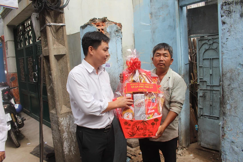 Ông Trần Quang Sang, Phó Chủ tịch UBND quận Phú Nhuận trao quà cho một hộ dân khó khăn tại hẻm. Ảnh: NGUYỄN YÊN Ông Trần Quang Sang, Phó Chủ tịch UBND quận Phú Nhuận trao quà cho một hộ dân khó khăn tại hẻm. Ảnh: NGUYỄN YÊN