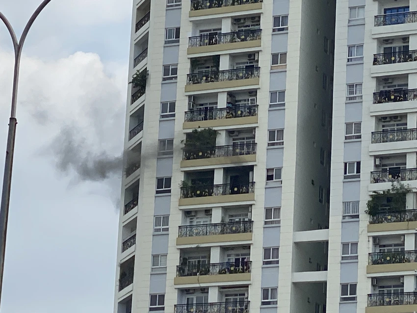 Khói đen vẫn bốc lên từ căn hộ ở tầng 11 tòa nhà lúc 13 giờ 15. Ảnh: HT