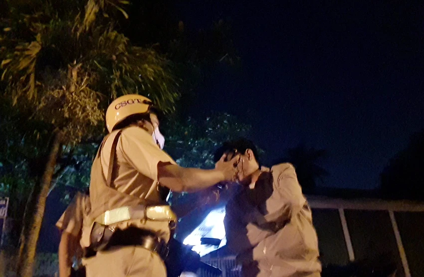 CSGT đang kiểm tra nồng độ cồn với người đàn ông. Ảnh: NGUYỄN YÊN CSGT đang kiểm tra nồng độ cồn với người đàn ông. Ảnh: NGUYỄN YÊN