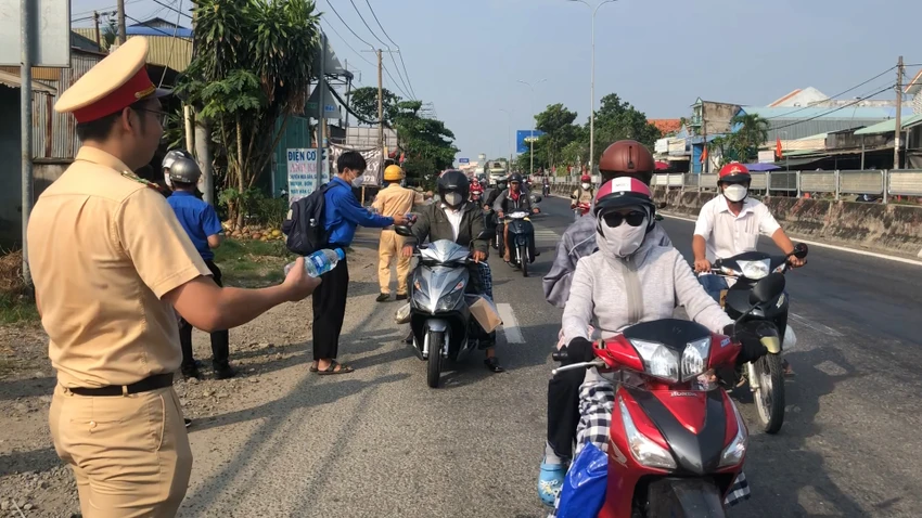 Chốt tặng nước suối, khăn, khẩu trang được tổ chức trên quốc lộ 1 hướng về miền Tây. Ảnh: NY Chốt tặng nước suối, khăn, khẩu trang được tổ chức trên quốc lộ 1 hướng về miền Tây