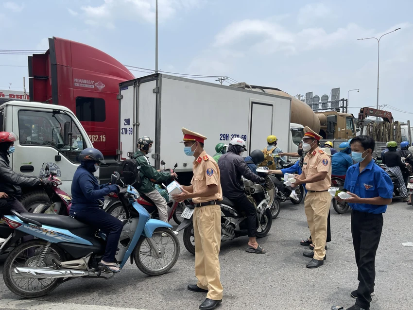 Các cán bộ CSGT Bình Triệu tặng khẩu trang cho người dân về quê. Ảnh: NY Các cán bộ CSGT Bình Triệu tặng khẩu trang cho người dân về quê