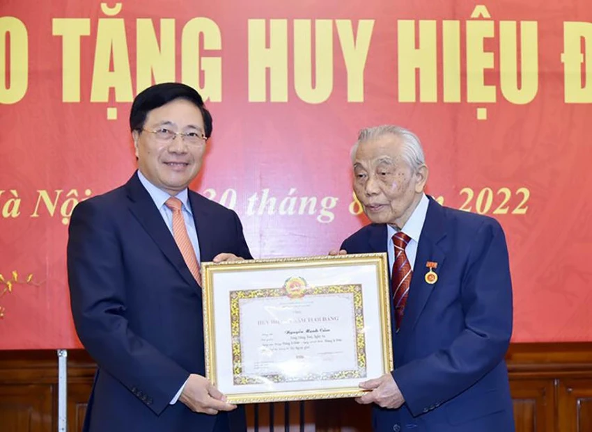 Phó Thủ tướng Phạm Bình Minh trao tặng Huy hiệu 75 năm tuổi Đảng cho nguyên Phó Thủ tướng Thường trực Nguyễn Mạnh Cầm. Ảnh: BNG