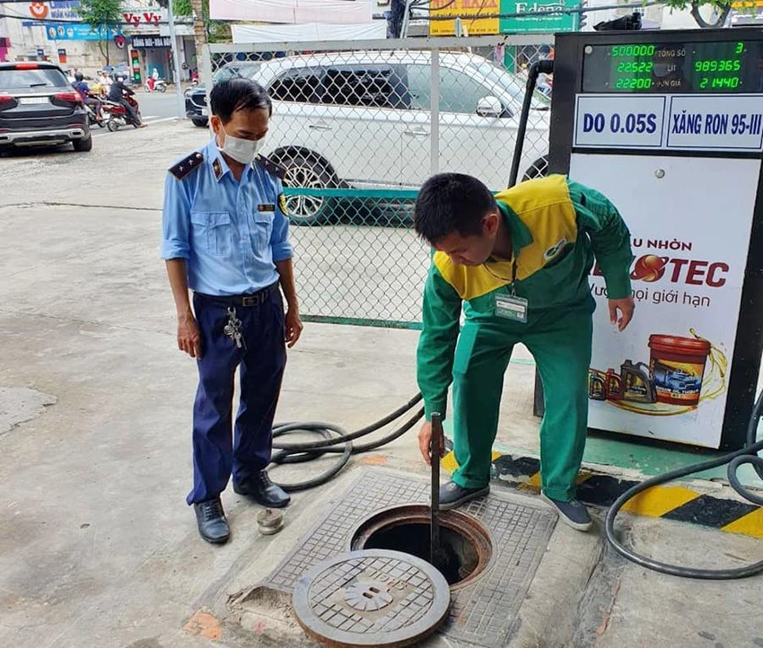 Kiểm tra, đo bồn tại cây xăng trên đường Hoàng Văn Thụ, phường 9, quận Phú Nhuận. Ảnh: NGUYỄN YÊN
