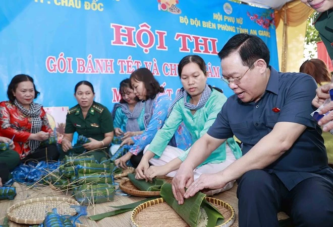 Chủ tịch Quốc hội Vương Đình Huệ cùng tham gia gói bánh chưng tại chợ Tết công đoàn 2023. Ảnh: TTXVN