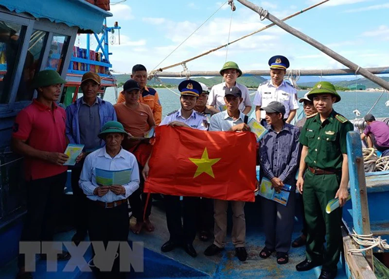 Lực lượng Cảnh sát biển tuyên truyền Luật Cảnh sát biển Việt Nam, Luật Thủy sản, tuyên truyền về IUU... cho ngư dân. Ảnh: TTXVN