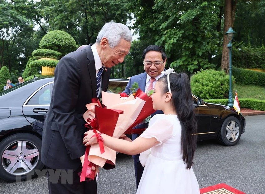 Thiếu nhi Thủ đô tặng hoa chào đón Thủ tướng Singapore Lý Hiển Long. Ảnh: TTXVN Thiếu nhi Thủ đô tặng hoa chào đón Thủ tướng Singapore Lý Hiển Long. Ảnh: TTXVN