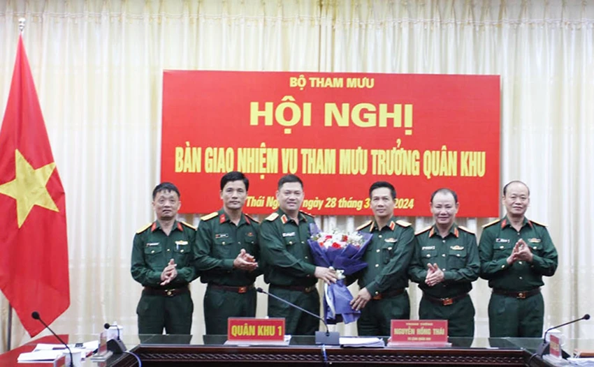 Trung tướng Nguyễn Hồng Thái, Tư lệnh Quân khu 1, tặng hoa chúc mừng Thiếu tướng Nguyễn Huy Cảnh (thứ 3 từ phải qua) nhận nhiệm vụ mới. Ảnh: VGP