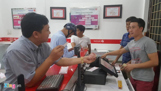 Người Hà Nội mua vé số tự chọn sát giờ quay tại một điểm bán trên phố Trần Quốc Hoàn chiều 16/7. Ảnh: Hiếu Duy. Giai doc dac xo so Vietlott co the can moc 130 ty hom nay hinh anh 1