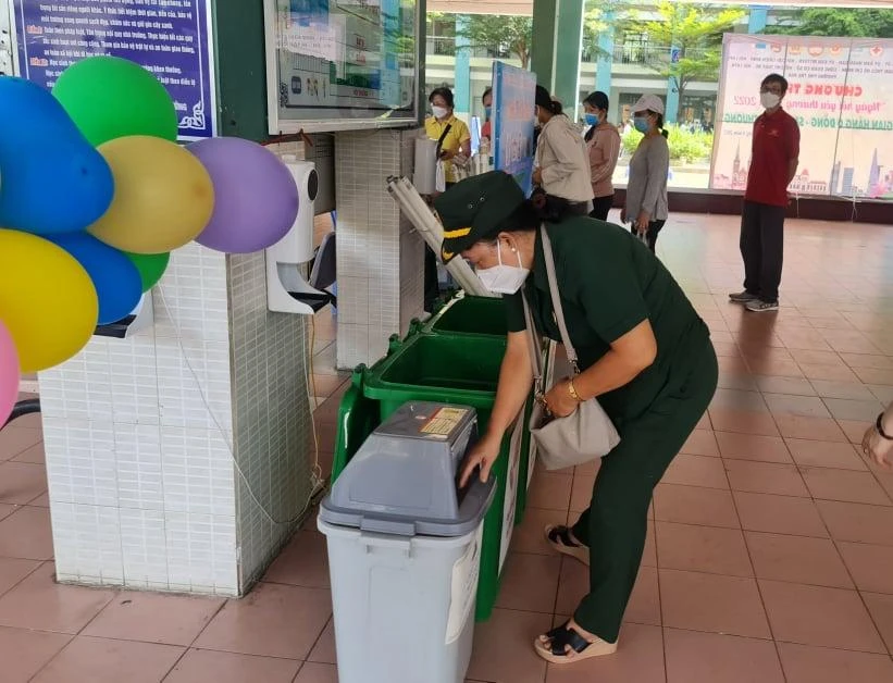 Hướng dẫn người dân phân loại rác. Ảnh: NGUYỄN CHÂU Hướng dẫn người dân phân loại rác. Ảnh: NGUYỄN CHÂU