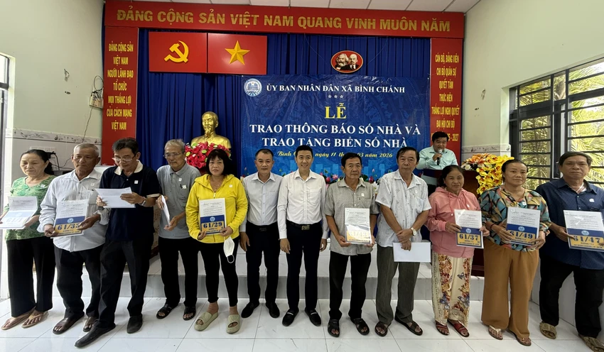 Lãnh đạo UBND xã Bình Chánh trao biển số nhà cho người dân. Ảnh: NGUYỄN CHÂU trao số nhà cho người dân ở xã bình chánh.jpg