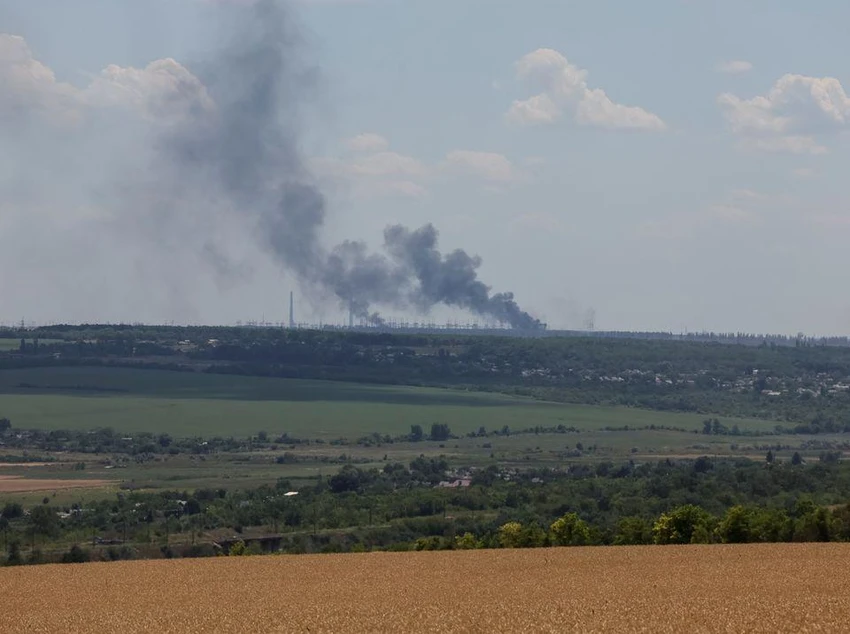 Nhà máy điện Vuhlehirsk bốc cháy phía xa sau trận pháo kích giữa Nga và Ukraine ở tỉnh Donetsk, ngày 13-7. Ảnh: REUTERS