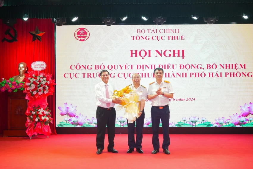 Chủ tịch UBND thành phố Nguyễn Văn Tùng và Tổng Cục trưởng Tổng cục Thuế Mai Xuân Thành tặng hoa chúc mừng Tân Cục trưởng Cục Thuế Hải Phòng. Ảnh: ĐT