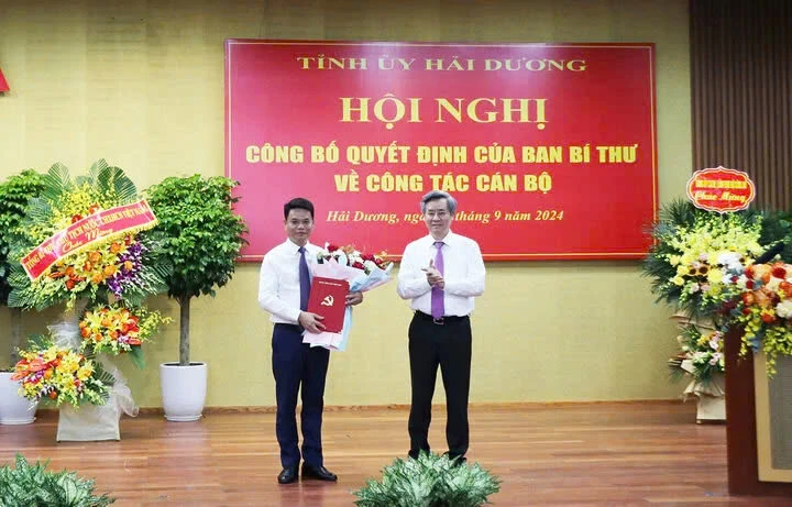 Ông Nguyễn Quang Dương, Phó Trưởng Ban Tổ chức Trung ương trao quyết định và tặng hoa cho ông Lê Ngọc Châu
