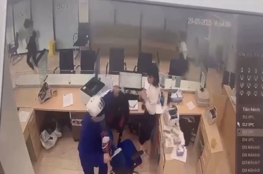 Người đàn ông cầm theo vật nghi là dao để cướp ngân hàng. Ảnh chụp từ clip