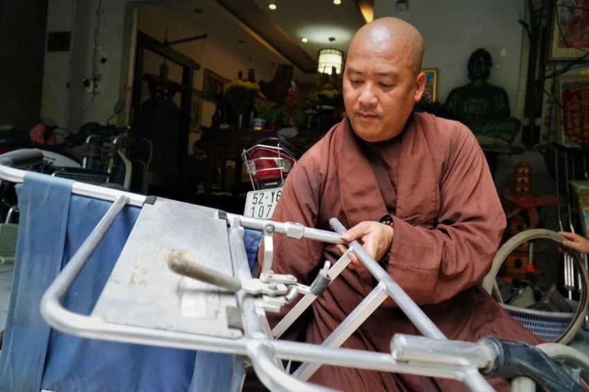 Sư thầy Đức Minh đang sửa chửa một chiếc xe lăn cũ. Sư thầy Đức Minh đang sửa chửa một chiếc xe lăn cũ.