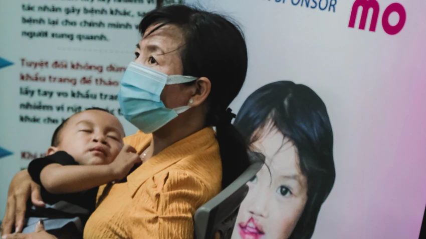 Em bé và người thân chờ thăm khám để phẫu thuật tìm lại nụ cười. Ảnh: THÙY LINH Em bé và người thân chờ thăm khám để phẫu thuật tìm lại nụ cười. Ảnh: THÙY LINH
