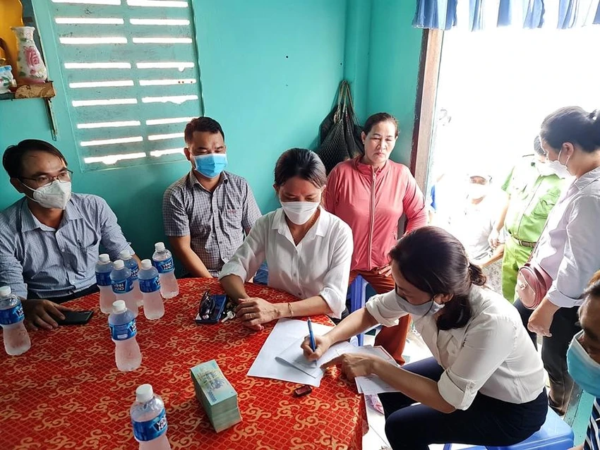 Đại diện UBND phường Lạc Đạo và Ngân hàng Chính sách xã hội Bình Thuận lập giấy giao nhận tiền. Ảnh: PN