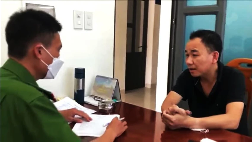 Điều tra viên lấy lời khai Phạm Văn Nam. Ảnh BÍCH THUẬN.