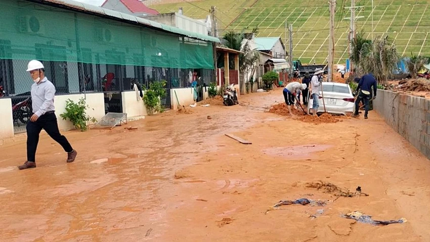 Nhiều người dân đang giải cứu một ô tô bị cát lấp. Ảnh: PĐ