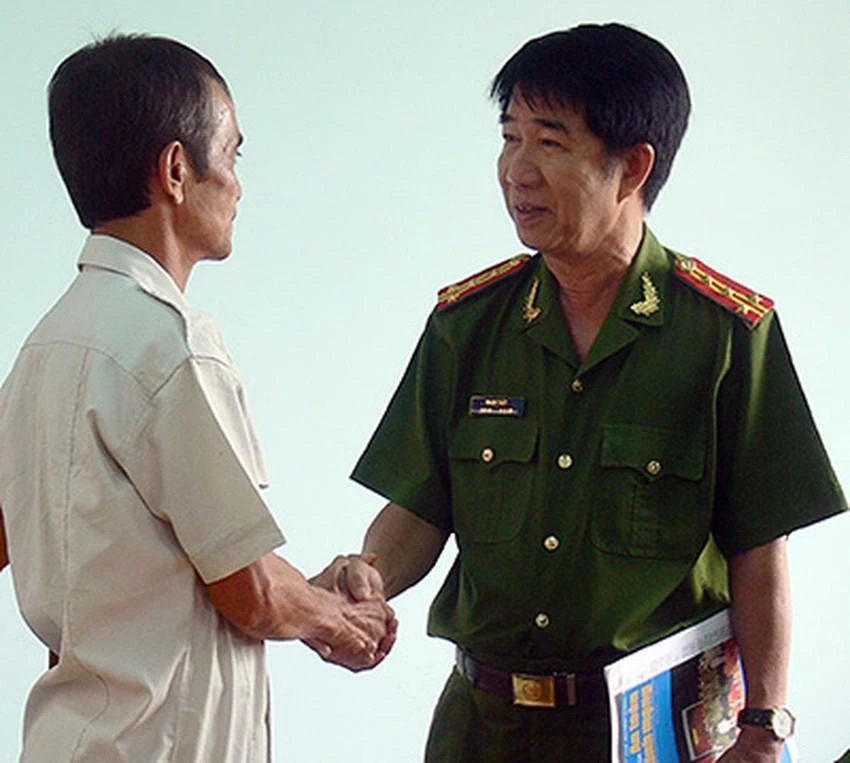 Đại Tá Phạm Thật, Phó giám đốc Công an Bình Thuận bắt tay chúc mừng ông Nén. Ảnh: PN