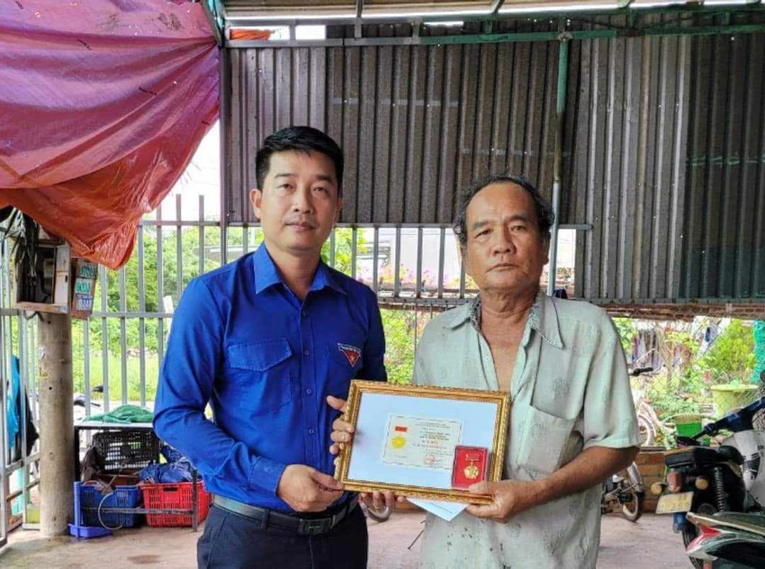 Phó Bí thư Tỉnh đoàn trao quyết định truy tặng Danh hiệu Tuổi trẻ dũng cảm cho cha ruột anh Nguyễn Hữu Đốn. Ảnh: NL