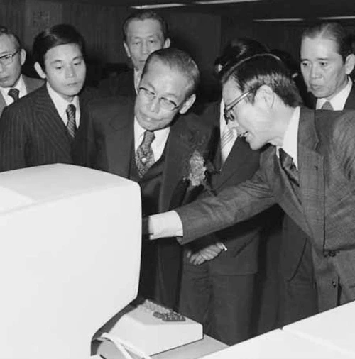 Ông Lee Byung-chull nghe giới thiệu về một hệ thống máy tính năm 1976. Con trai ông đứng bên trái. Ông Lee Byung-chull